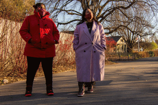 two women in winter coats on a walking path